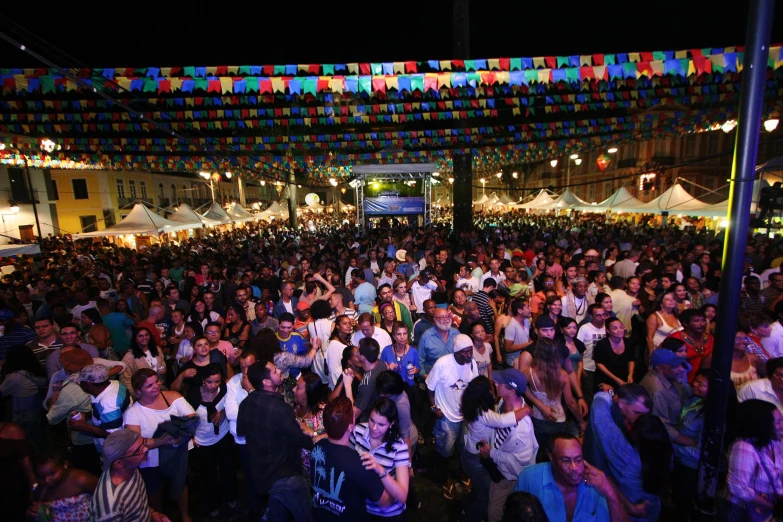 a huge group of people standing in front of some tents and lights