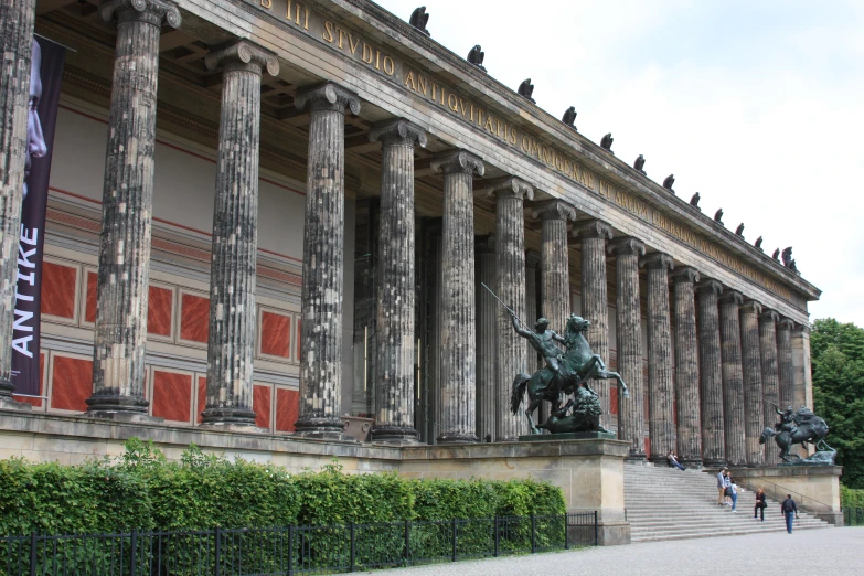 a statue stands in front of an ornately designed building