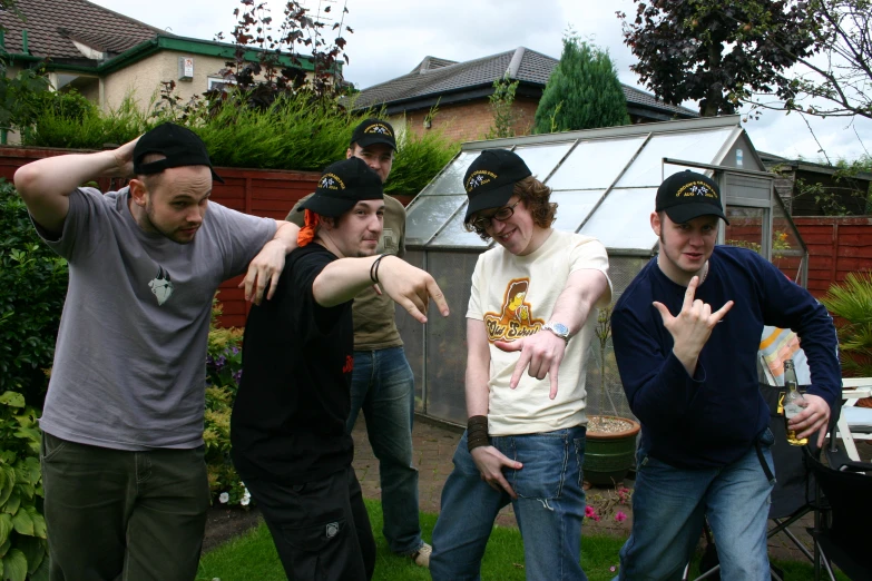 seven young men are posing in a backyard