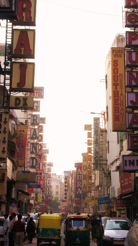 a busy city street has various signs and vehicles on the sidewalk