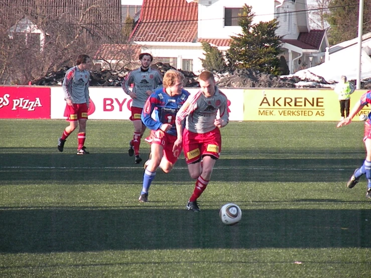 two teams of female soccer players chasing the ball