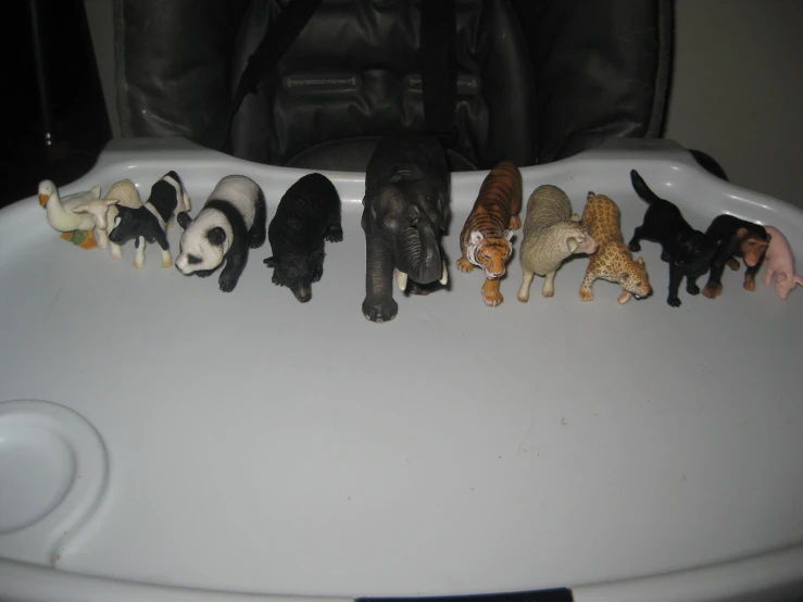 many fake animals lined up on top of an empty dish