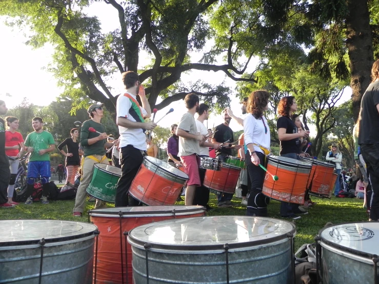 a group of people standing around and playing drums