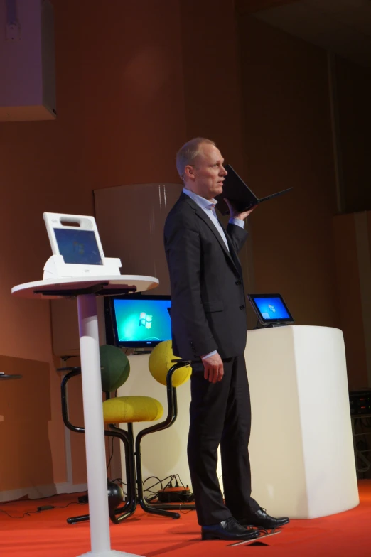 a man in a suit and tie with two monitors