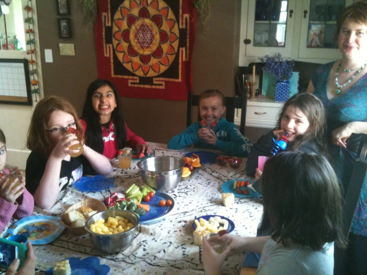 a group of people gathered around a table with plates of food