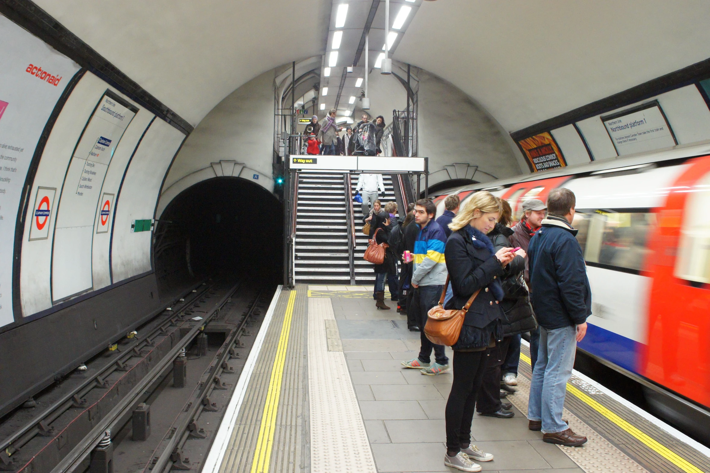 a group of people waiting on an underground subway platform