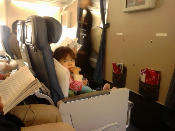 a baby sitting on top of an airplane seat