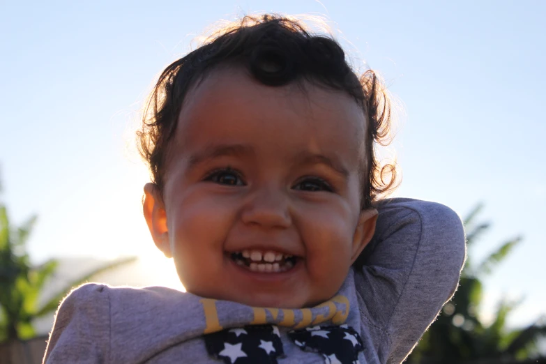 a small child smiles while wearing a star print bowtie