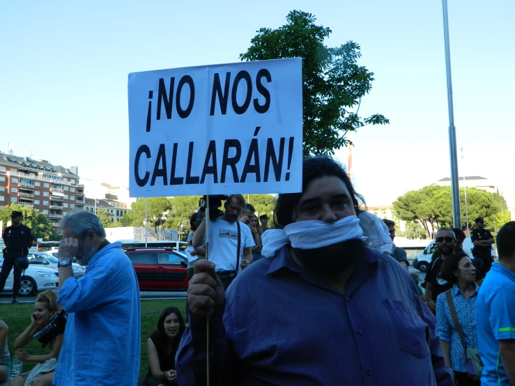 a man standing next to a crowd with an odd sign