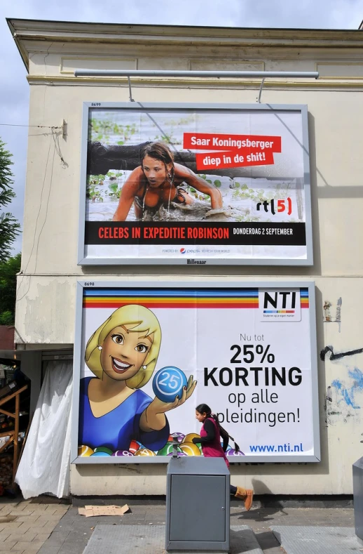 large posters advertise women in front of a building