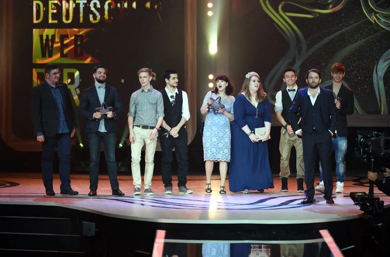 people standing on a stage with their award