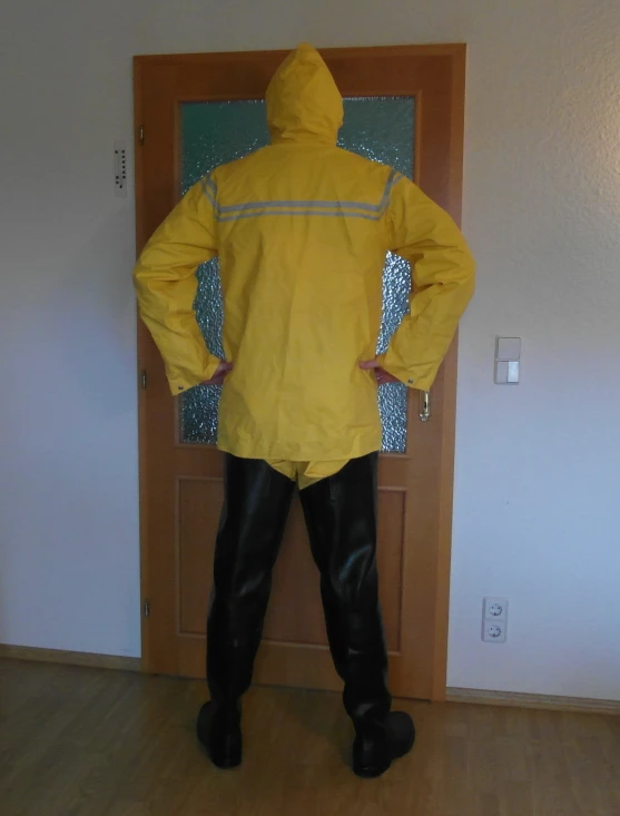 man in yellow rain coat standing in room