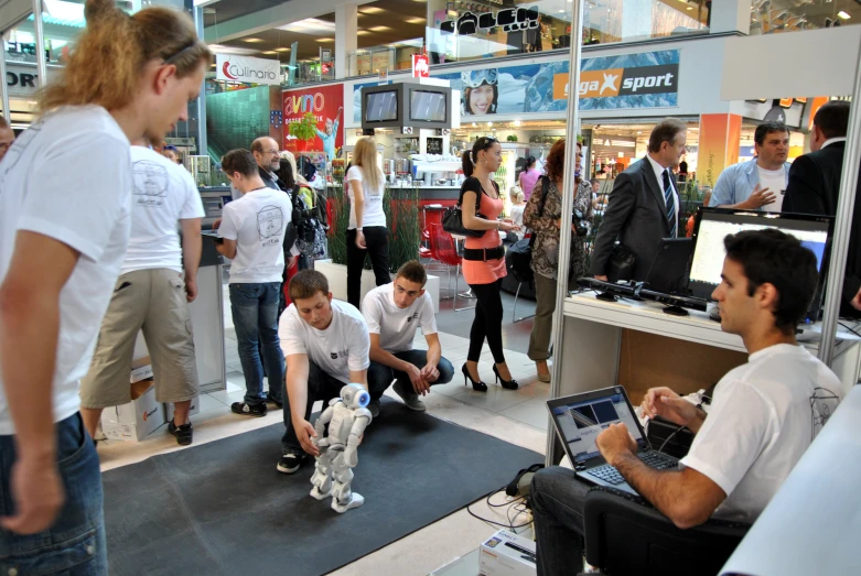 people in a store looking at computers and people watching