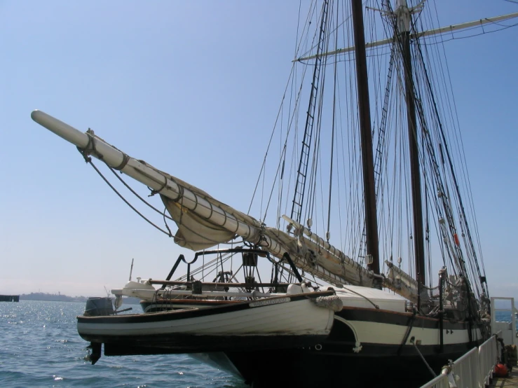 a white and black boat docked with other sailboats