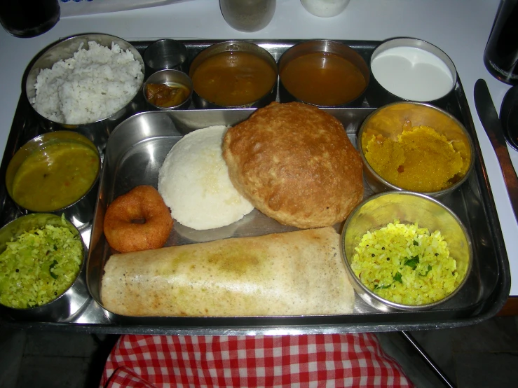 a metal tray with various food items on it