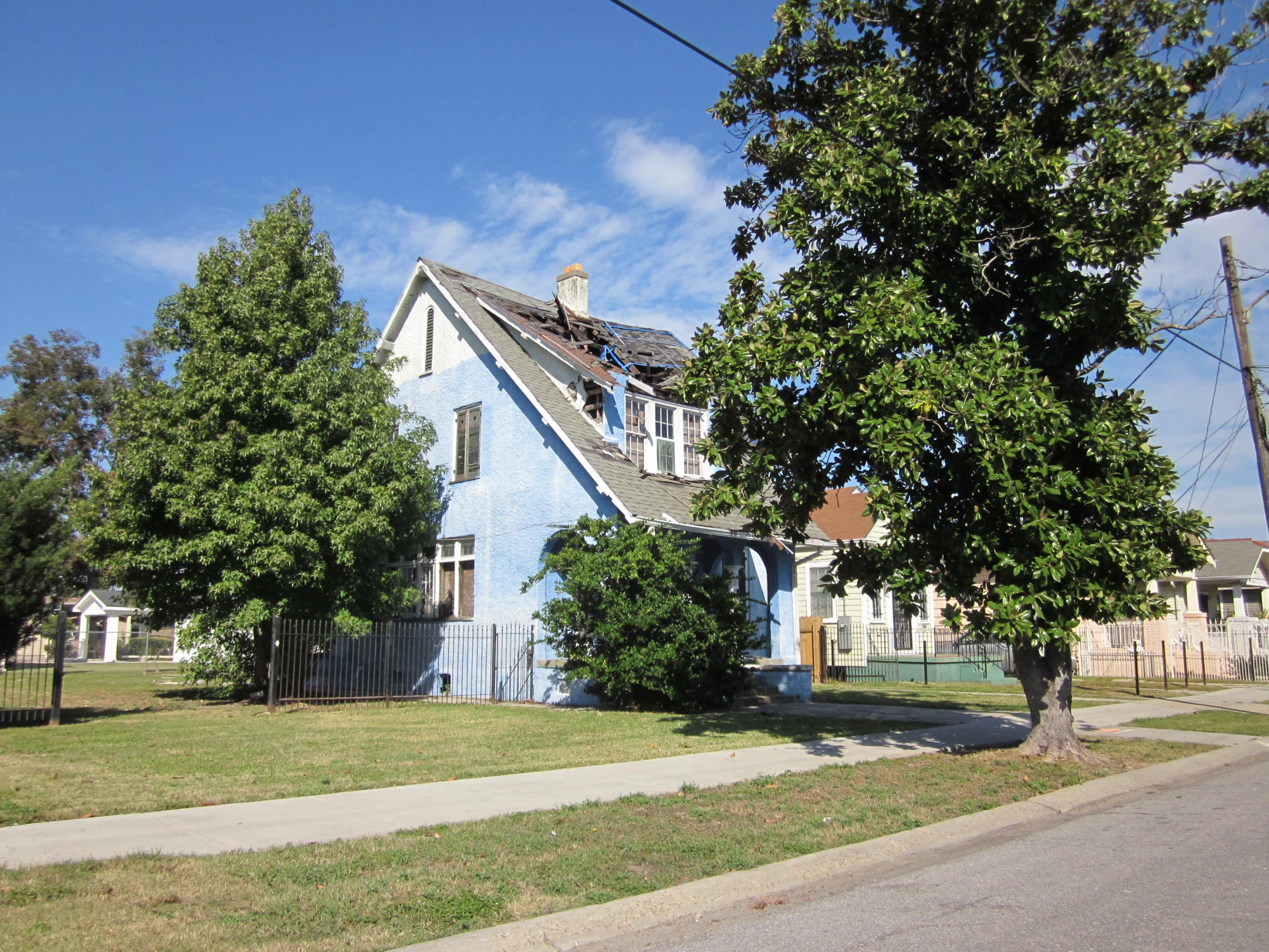 blue house with white trim on a residential street corner