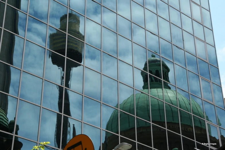 a building with some very tall towers in the reflection of it