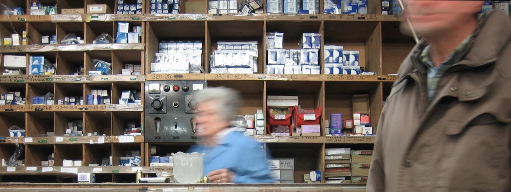 a person looking at shelves with bottles and boxes