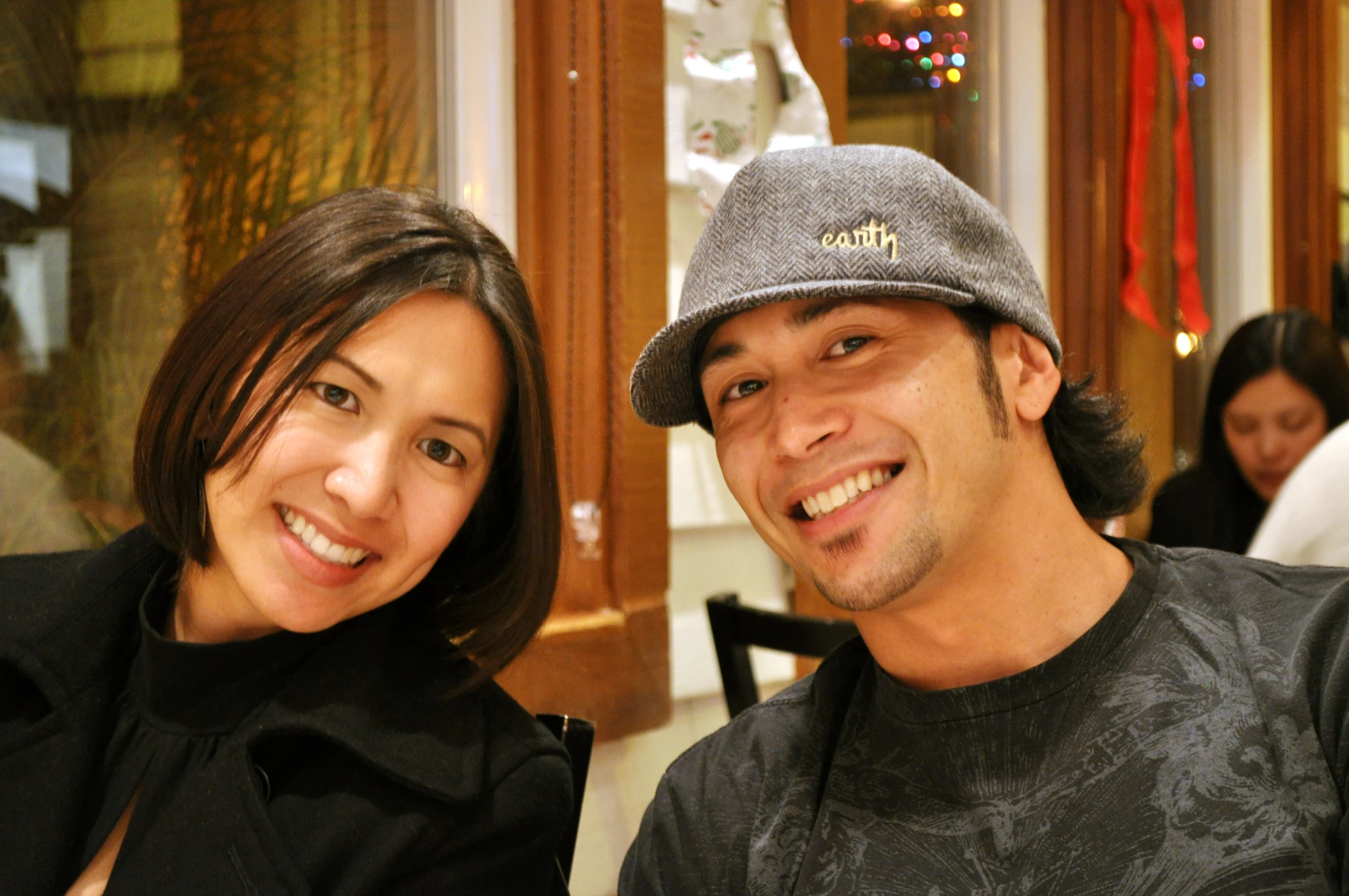 a man wearing a baseball cap next to a smiling woman