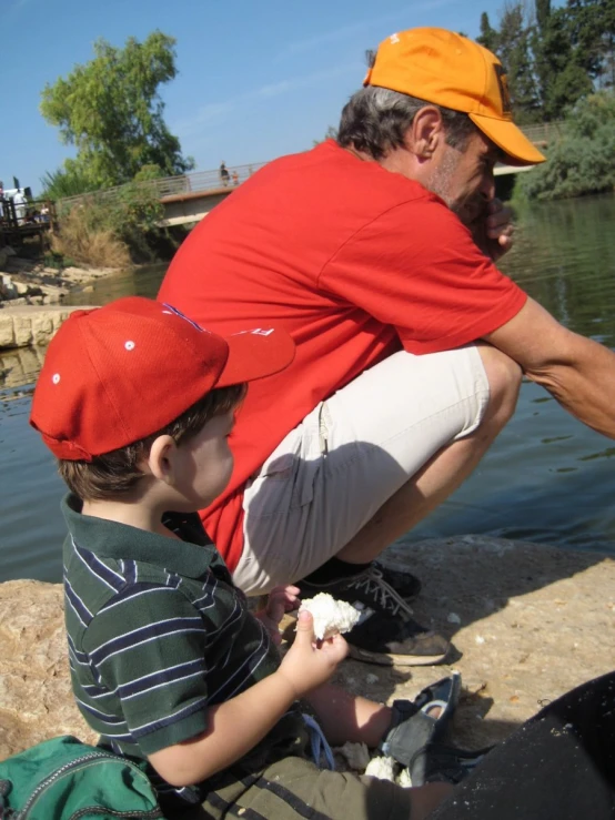 an older man and his son watching soing by the water