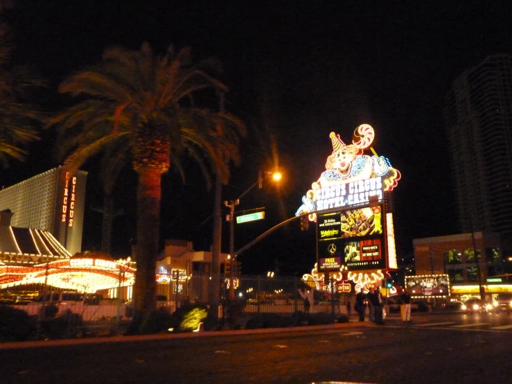 a busy street at night with palm trees and els