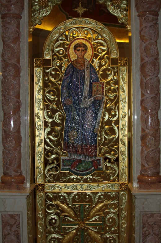 an ornate golden painted statue with a religious image in the background