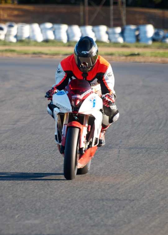 a man riding on the back of a red and white motorcycle