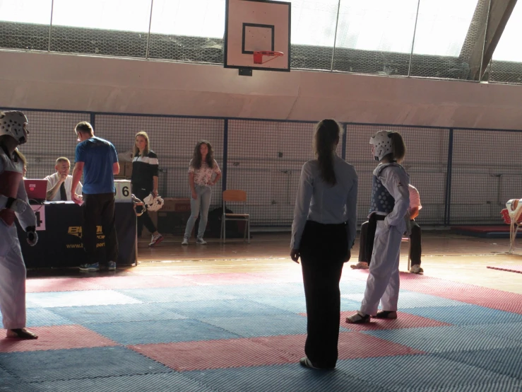 a group of people practicing karate inside a gym