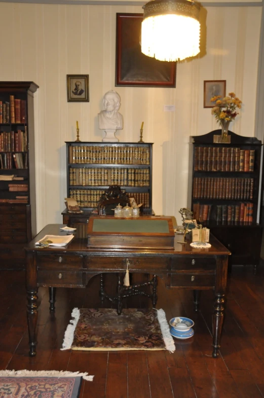 the room is furnished with books and antique furniture