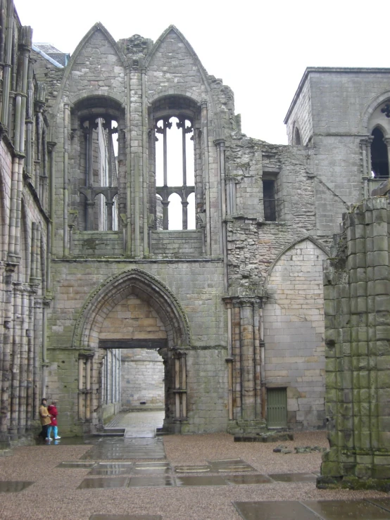 there are two people that are standing under an arch