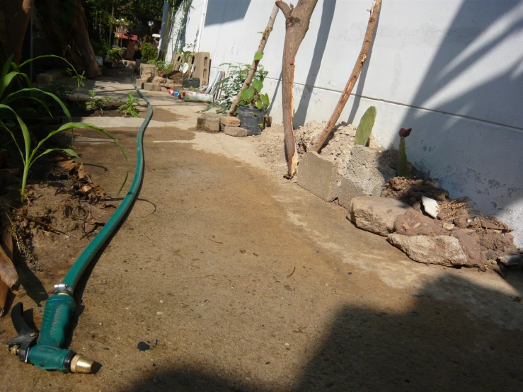 a blue hose running down a narrow sidewalk