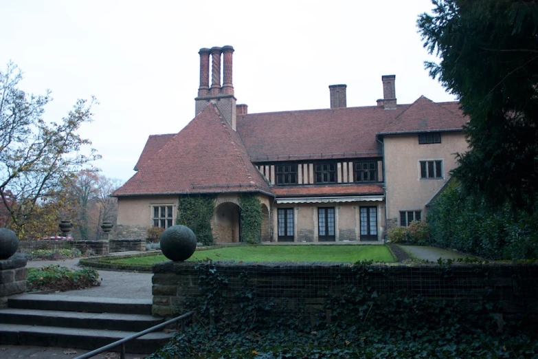 an old style mansion with a large garden in front of it