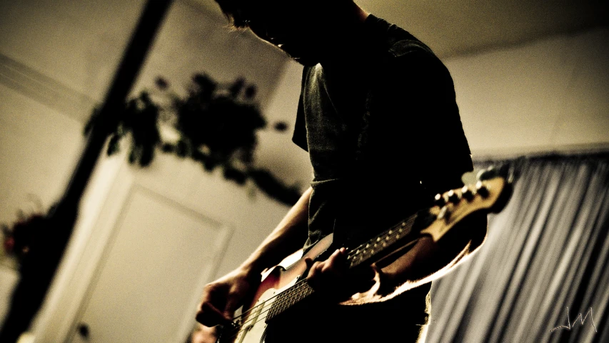 a man plays guitar in a dimly lit room