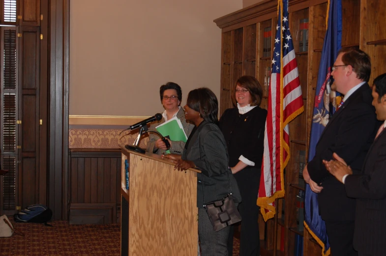 a man standing at a podium while speaking at a microphone