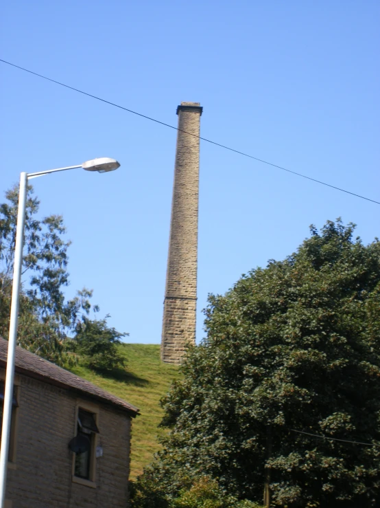 a stone chimney is on the hill above houses