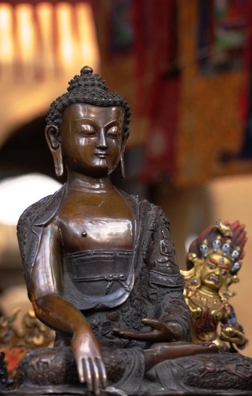 bronze statue of buddha sitting on a rock