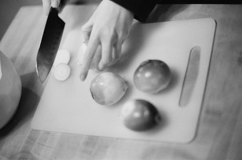 a person chopping vegetables on a  board