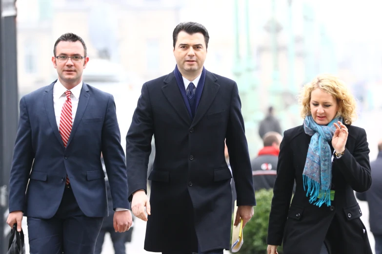 two businessmen dressed in business attire walking down the street