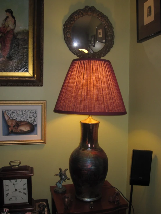 a lamp is lit in a bedroom with pictures