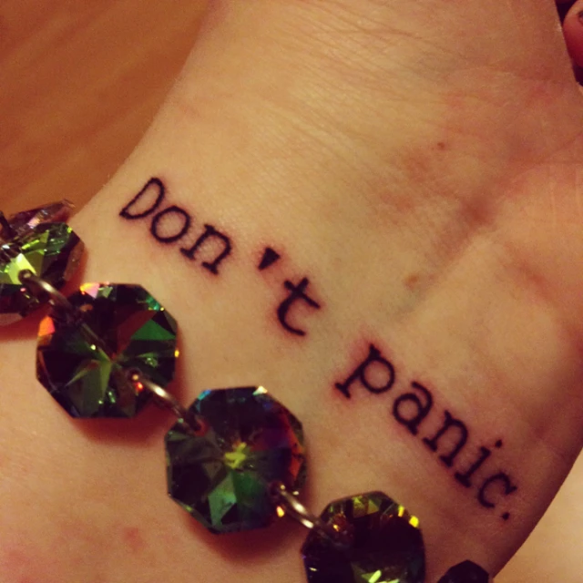 a person has a tattoo that says don't panic