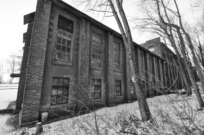 a very old brick building next to trees in the woods