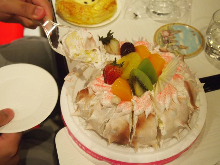 the small cake with fruit on top is displayed