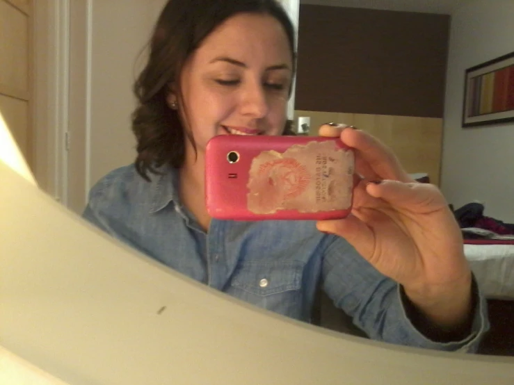 a woman taking a selfie in the bathroom mirror