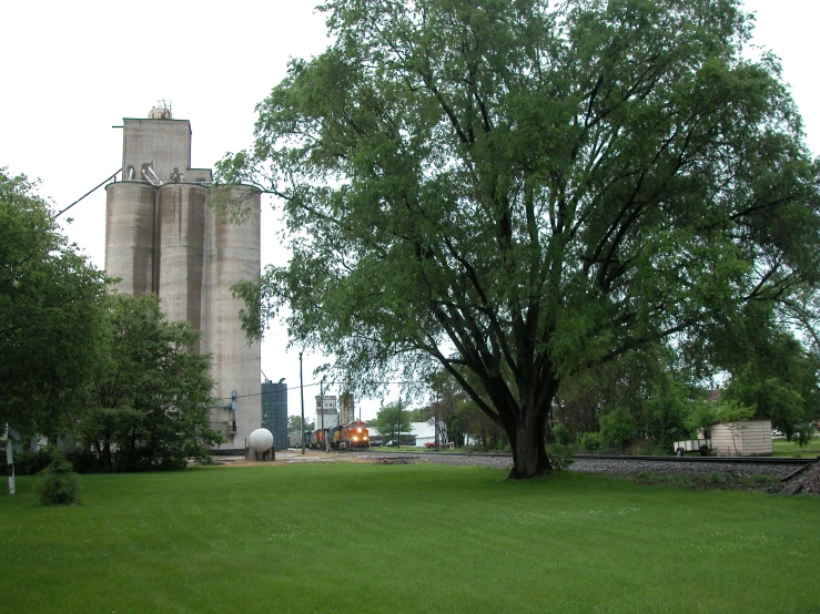 a large tree in front of a huge industrial building