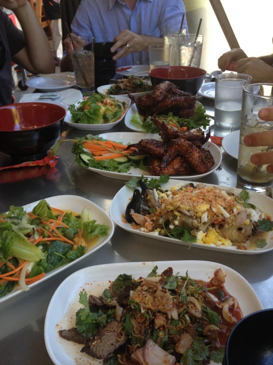 an oriental restaurant with dishes, wine glasses, water and other food