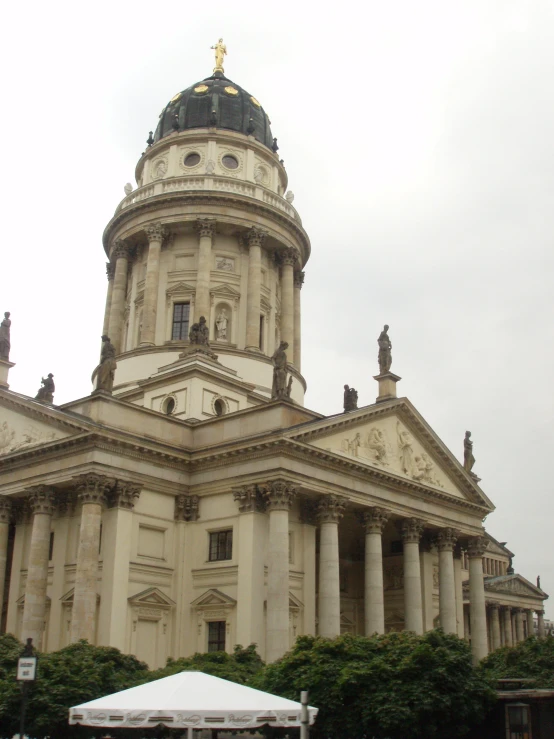 an old building with a steeple and a tower with a statue at the top