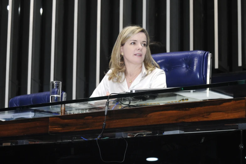 a woman with blonde hair is sitting in an auditorium