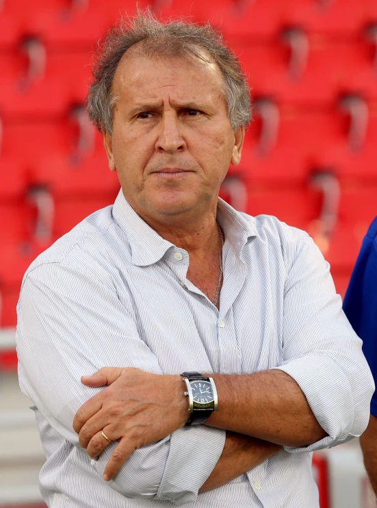 an older man standing with his arms folded