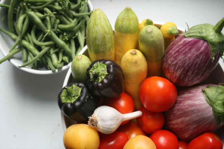 a table full of assorted vegetables and one with a pile of beans