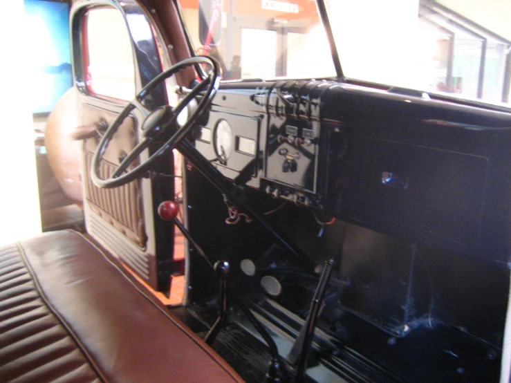 the interior of a vehicle with a car steering wheel and leather seats